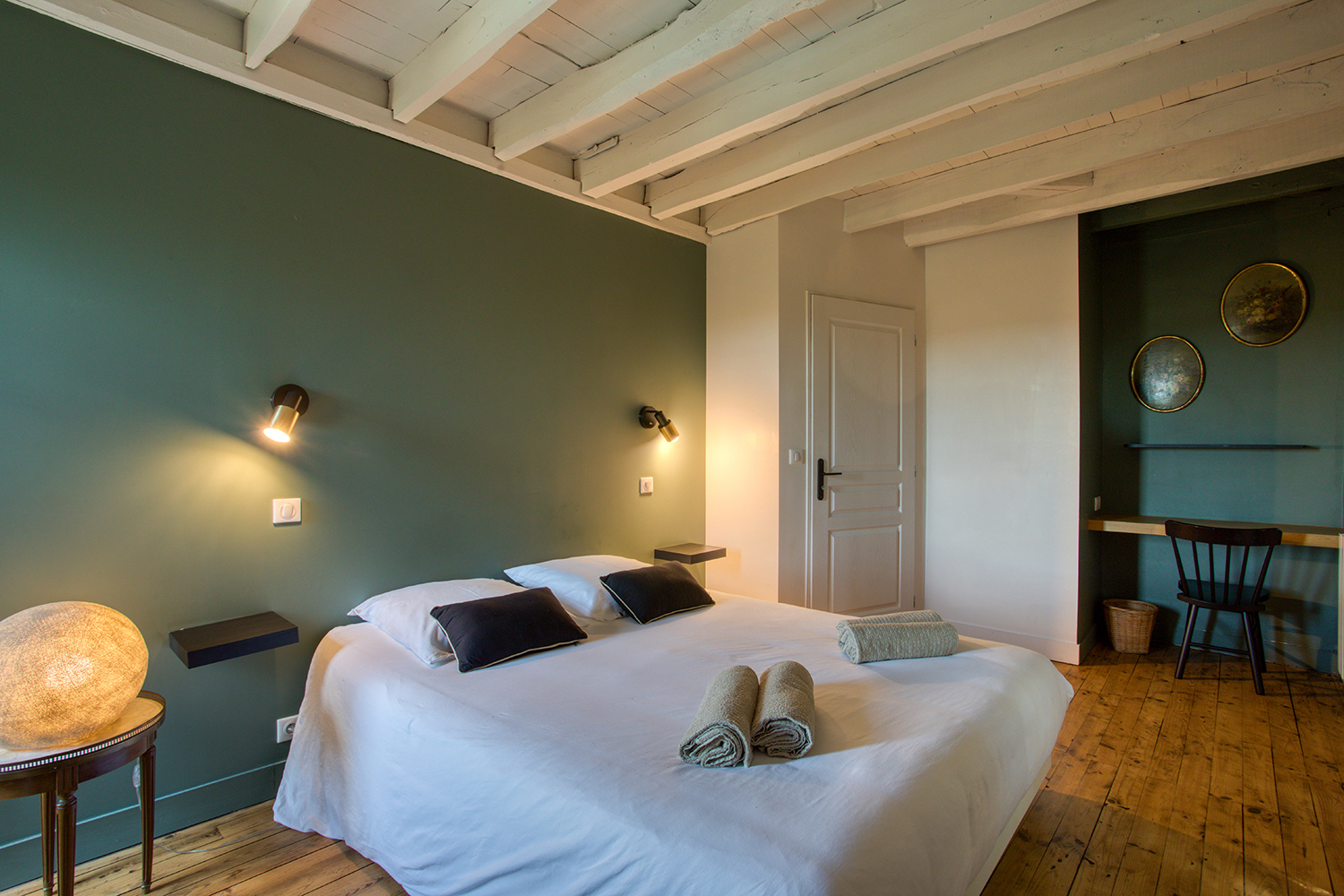 Chambre aux murs vert profond et coin bureau