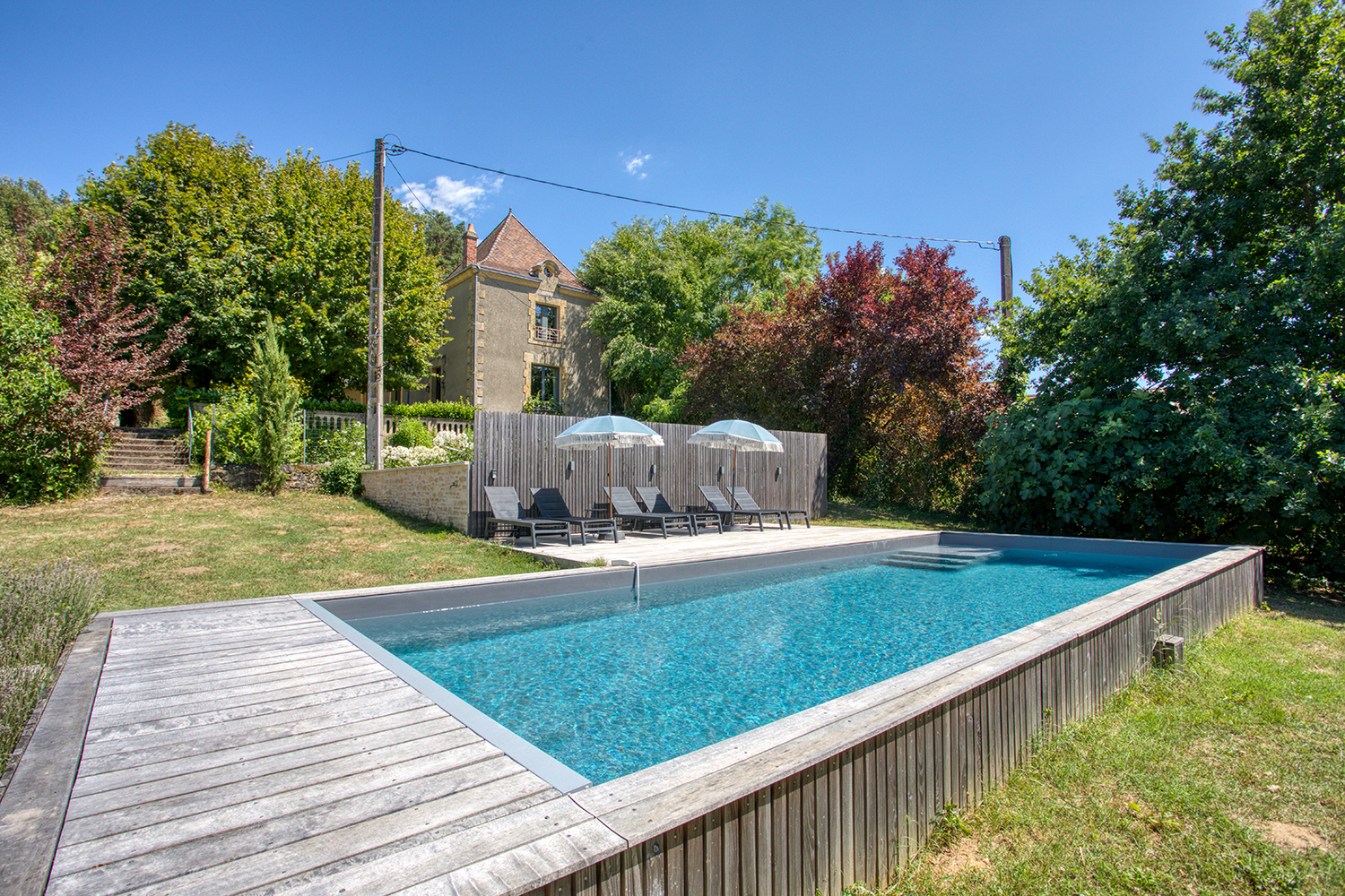 Piscine et maison en pierre dorée